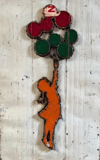 Stahlbild nach Banksy: fliegende Figur mit Ballons, Orange auf hellem Metallgrund