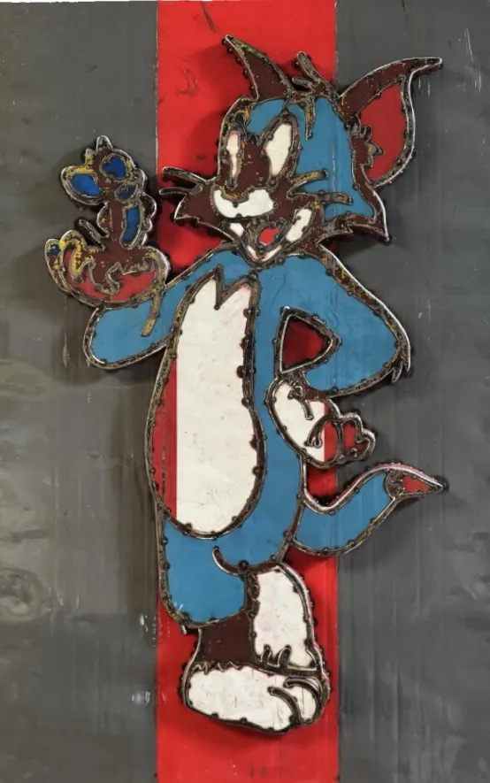 Stahlbild von Tom mit Jerry in der Hand, blaue Figur auf grauem Grund mit rotem Streifen